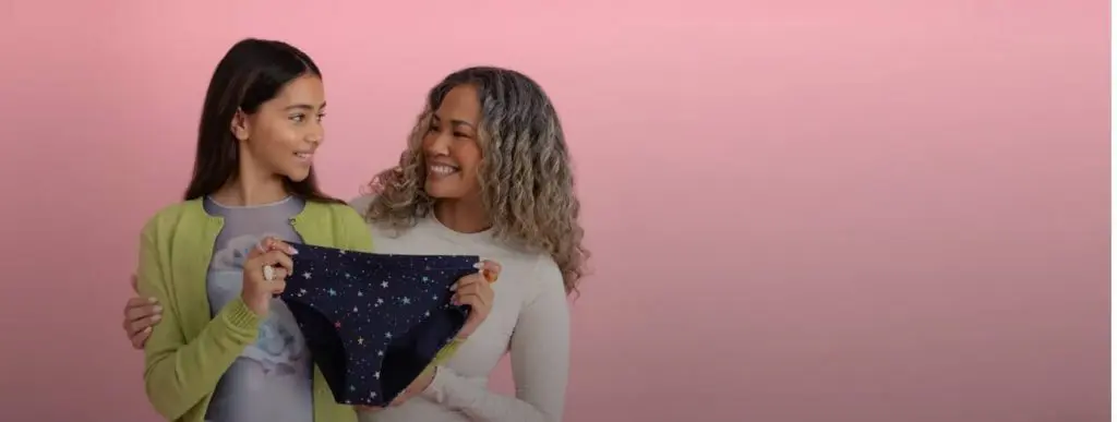 Thinx period underwear held by a mother and daughter on a pink background