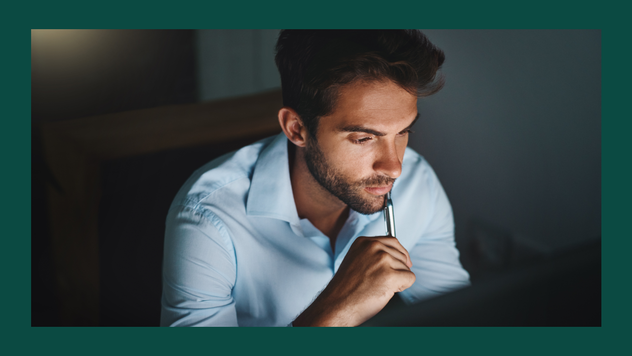 A man looking pensively at a screen while considering if he should register a domain under a fake name.