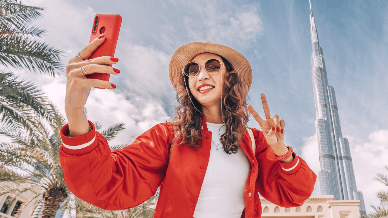 Image for "how to create a travel website" - A woman taking a selfie in an iconic location