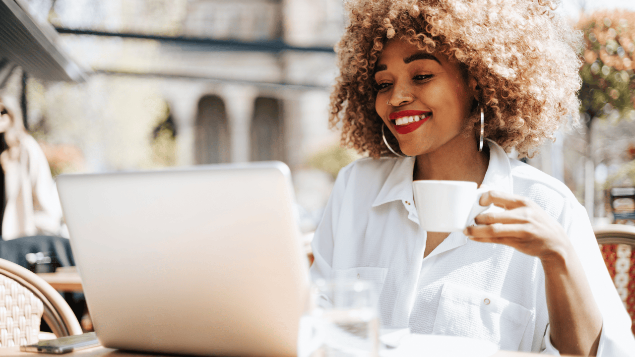 Woman exploring online business ideas on a laptop while enjoying coffee.