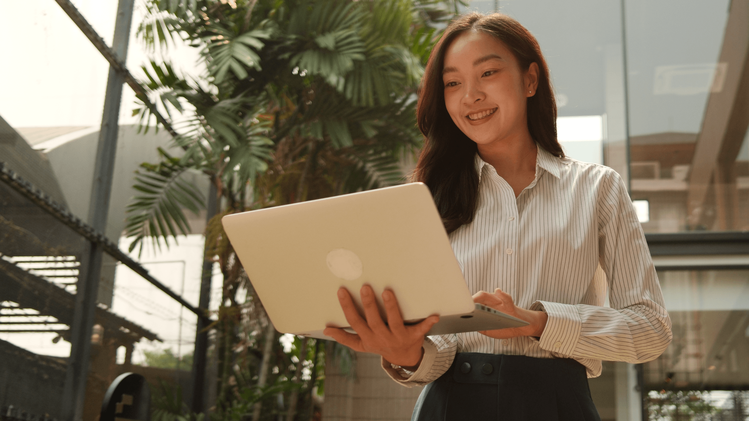 A woman smiling and holding a laptop with an 'https://' speech bubble floating above it.
